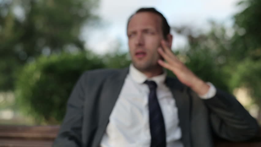 Portrait of  depressed businessman in the park, close up