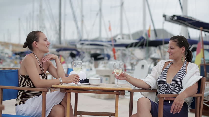Happy glamour female friends relaxing in marina