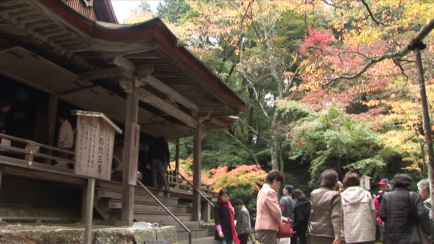 Kyoto, Japan - CIRCA November, 2006: Tourists in front of a classically designed Japanese Buddhist temple in a forest during the day