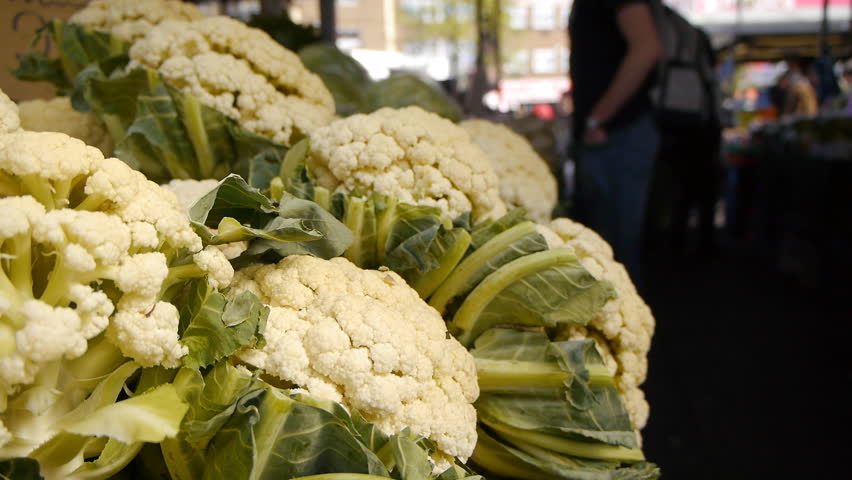 Cabbages for sale in a busy market.