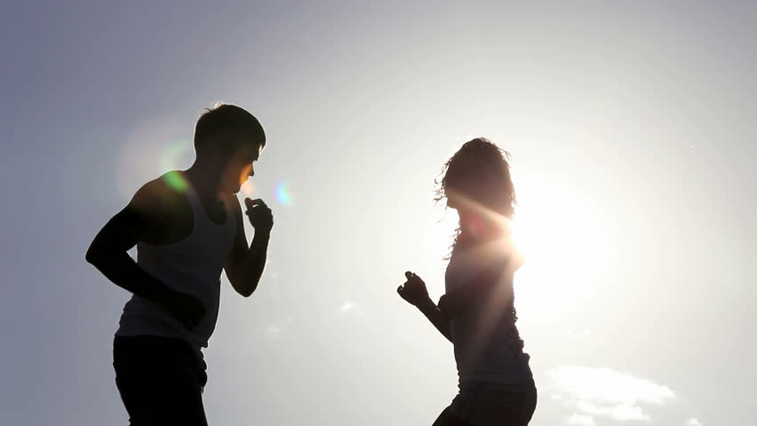 Silhouette couple dancing at the beach over sun