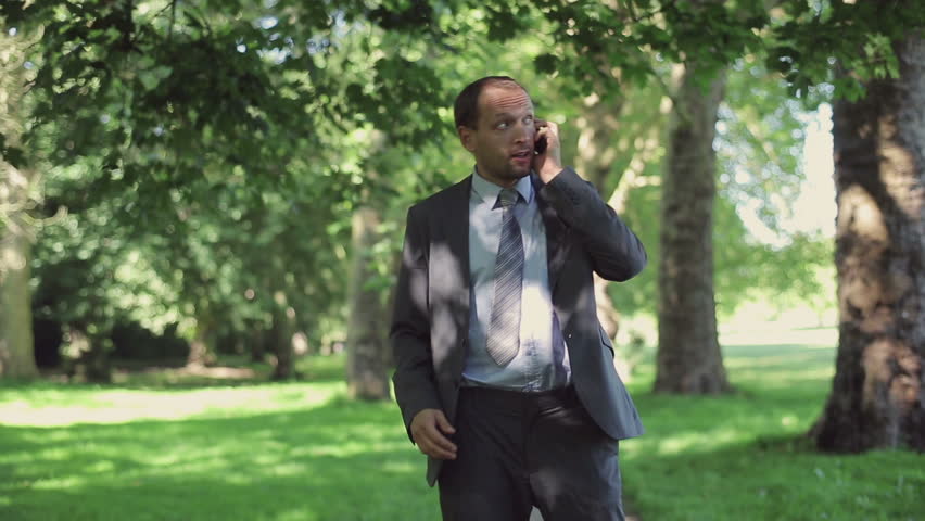 Businessman receiving phone call during jogging in park