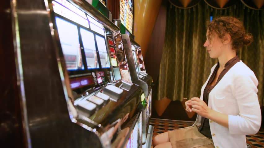 woman plays with slot machine and discontentedly poses face
