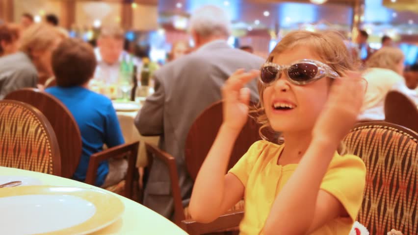 girl behind little table at restaurant wearing spectacles blinking multi-colored diodes