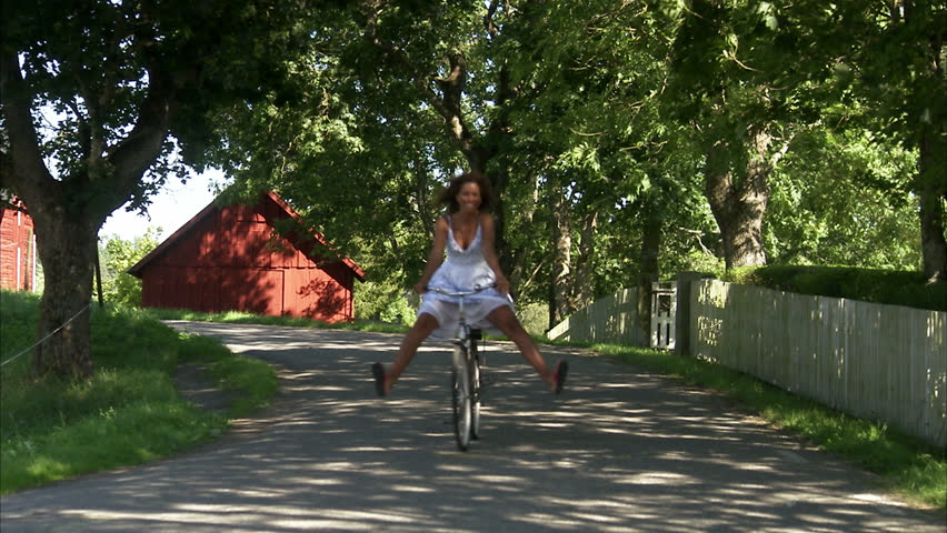A woman riding a bike in the countryside.