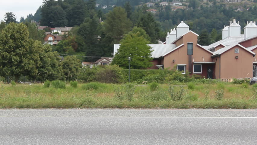 Cars and trucks speed past on a busy highway/Speeding Traffic/Vehicles speed past on a busy highway