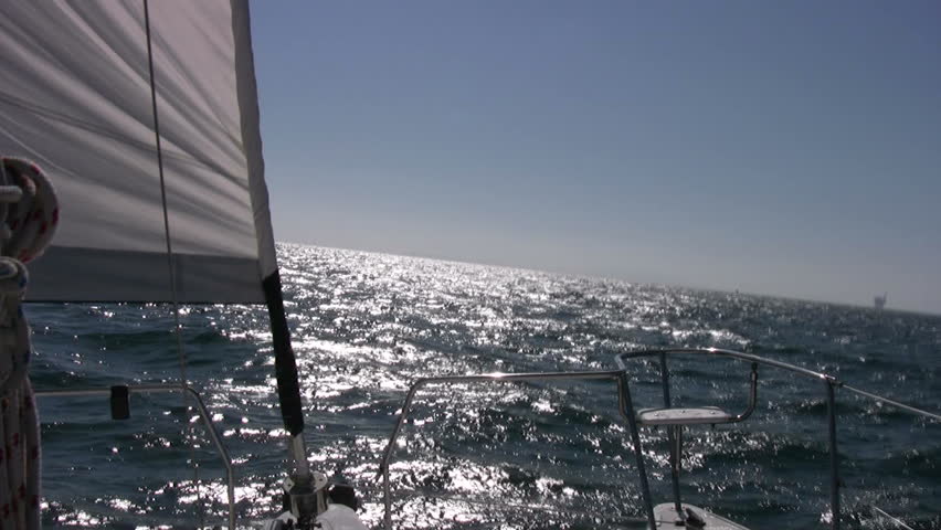 A catamaran sailboat racing across the sea