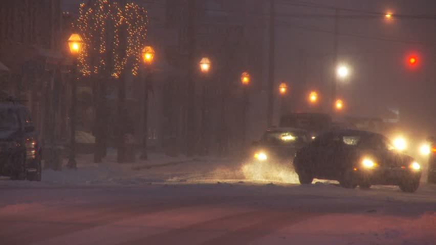 NEW ENGLAND - CIRCA NOVEMBER 2009: Small downtown scene with cars and lights during heavy snow storm at night