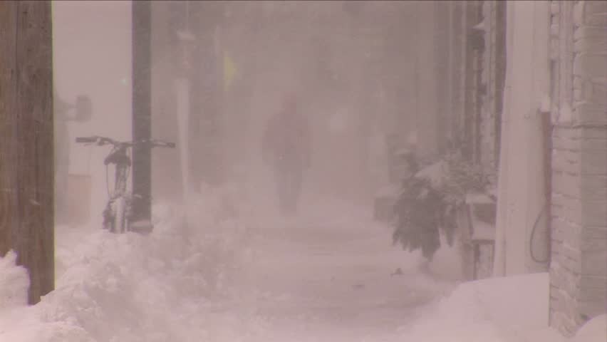 NEW ENGLAND - CIRCA JANUARY 2006: Man walking along a sidewalk in blizzard