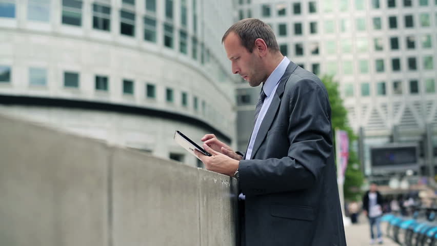 Businessman working on tablet computer in the city
