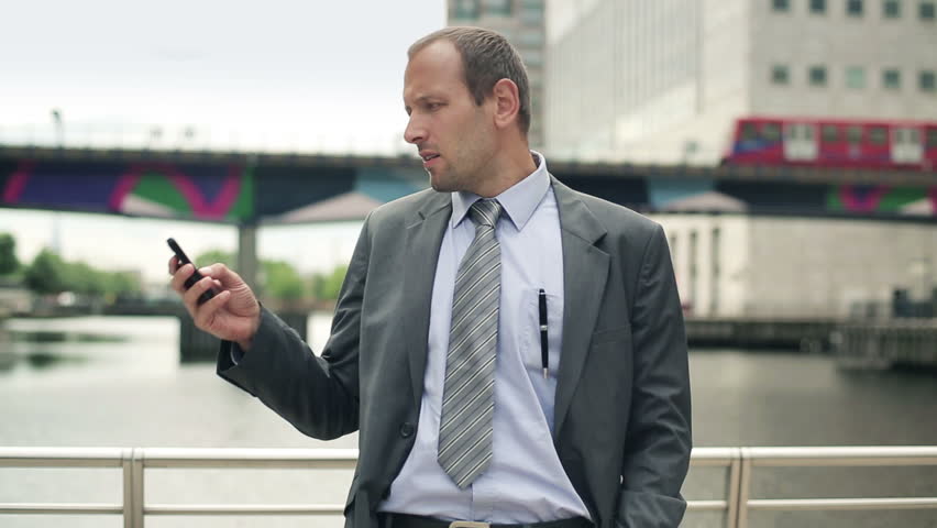 Young handsome businessman talking on mobile phone in the city
