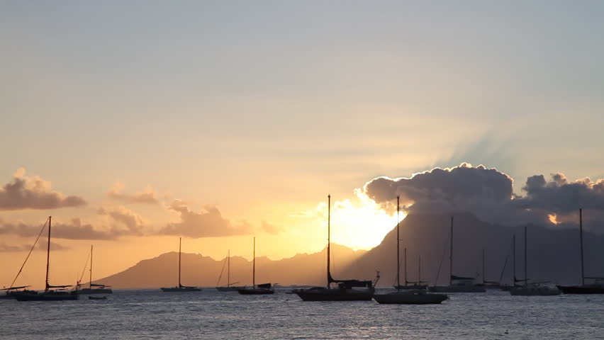 Sunset behind Moorea Island Mountains seen from Tahiti, in French Polynesia. (Realtime)
