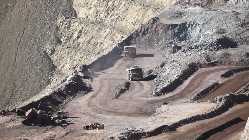 Heavy equipment digs and hauls ore inside an enormus open pit mine.
Chile