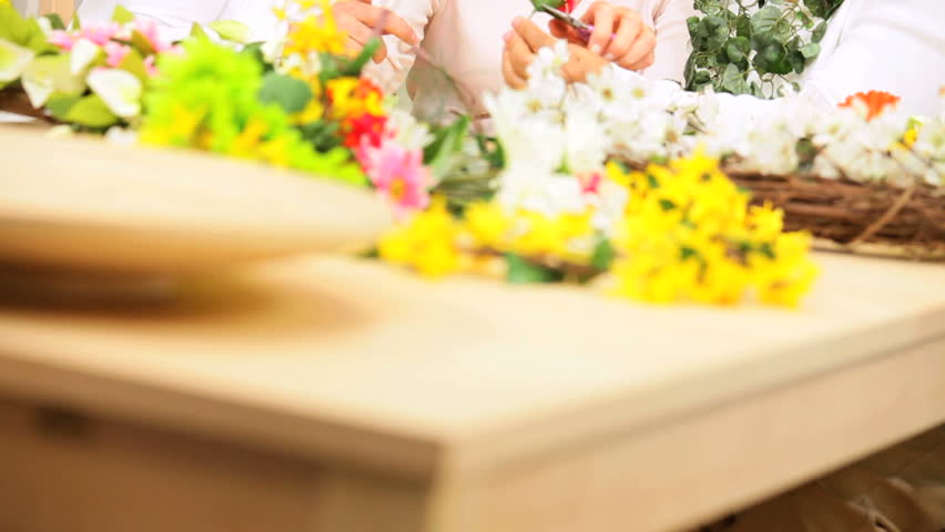 Attractive older ladies enjoying hobby time working with silk flowers home