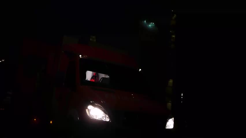 a german ambulance car with flashing beacon at night is shown, emergency