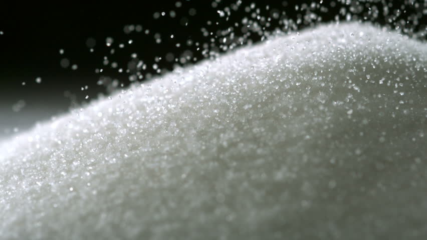 Pile of sugar on black background shooting with high speed camera.