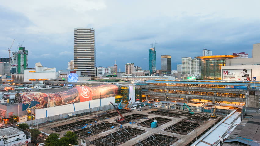 BANGKOK - JULY 15: Time lapse view of Siam BTS Station (Bangkok Aerial subway) and a mall with giant Coca-Cola Bottle as rooftop on July 15, 2012 in Bangkok, Thailand.