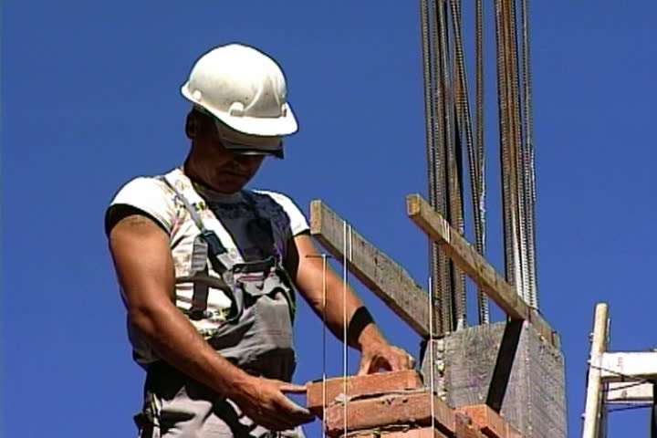 construction worker makes a wall of bricks