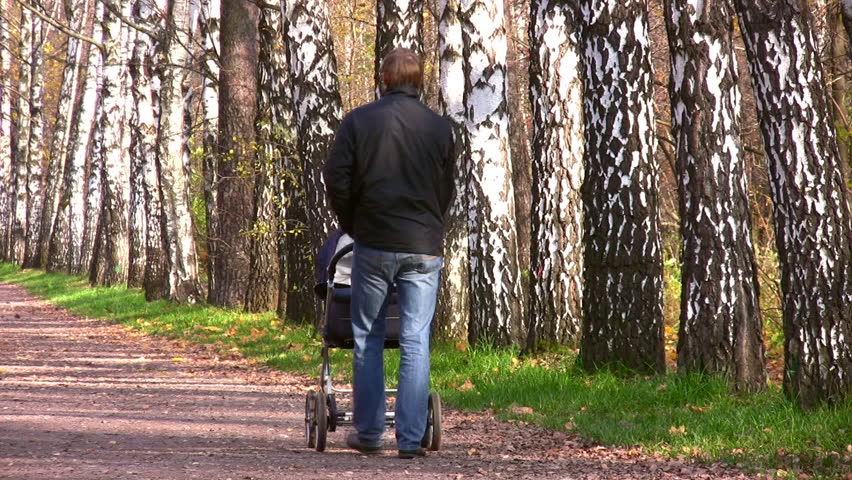 father with baby carriage in park