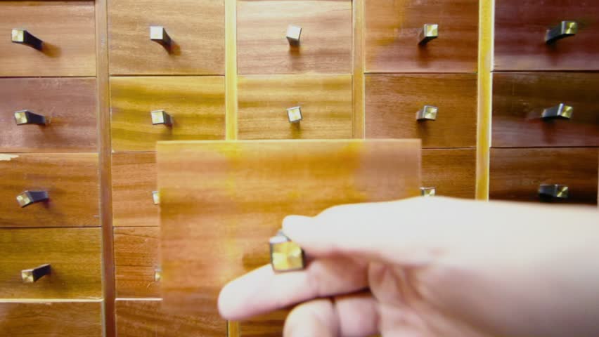 Hand opens box in cabinet and takes cd disk from it, then close