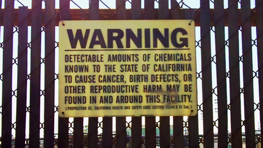LOS ANGELES, CA/USA - August 2, 2012: A warning sign at an oil refinery warns of the health risks of exposure to hazardous chemicals present at the site circa 2012 in Los Angeles,
