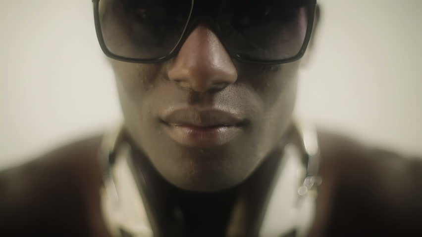 young african guy looking to the camera with glasses. Tilt shot.