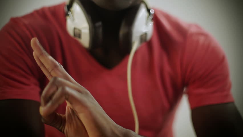 young african guy waving and dancing with a cool attitude, with glasses and red t-shirt.