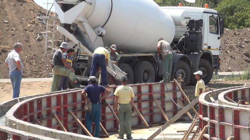 ROMANIA, BUCHAREST, JULY 24, 2012, Concrete Workers Pouring Wet Cement Down Chute