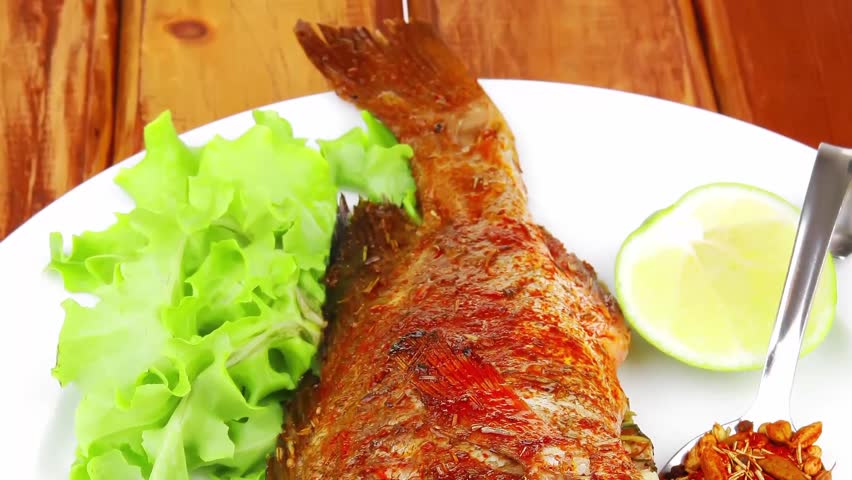 savory on wood: fried fish served with tomatoes lemon and spices