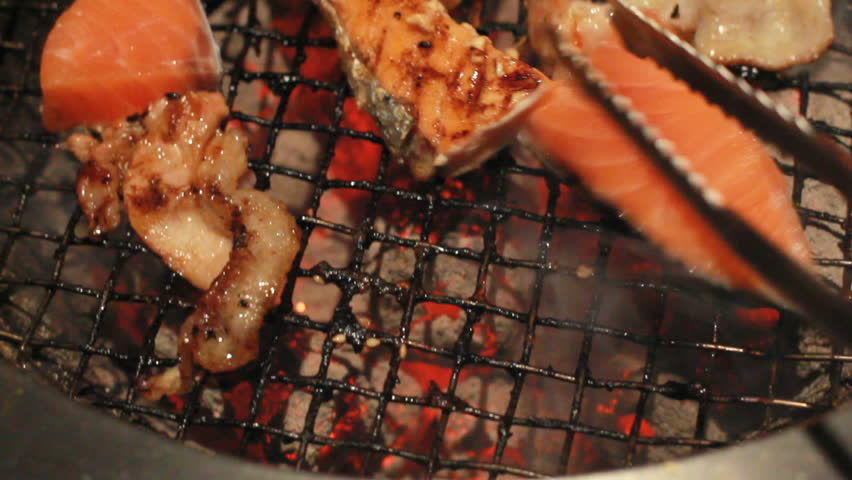 tongs reverse BBQ meat on grill