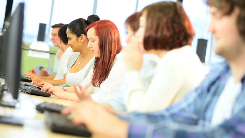 Female and male multi ethnic people learning technology subject online in library on computers