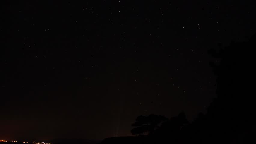 Time lapse of the night sky with clouds and stars passing by behind mountain. Noviy Svet, Crimea, Ukraine
