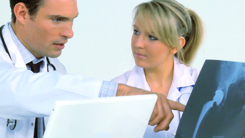 Young doctor & nurse examine patient records
