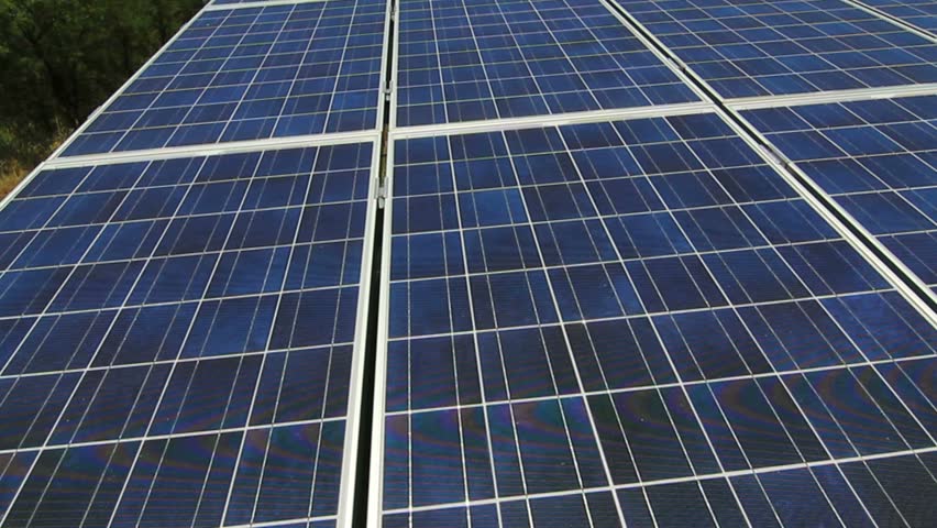 Sail across solar panels, close up, set amongst grass, trees. 1080p
