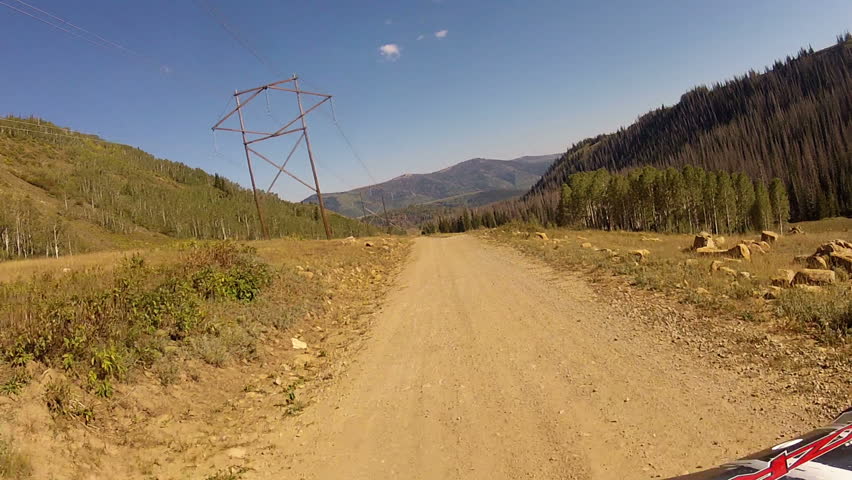 ATV on mountain road power electric transmission line. Fun outdoor recreation. Riding in the Rocky Mountains in the Manti LaSal National Forest. Famous Skyline drive and Arapeen OHV Trail. 
