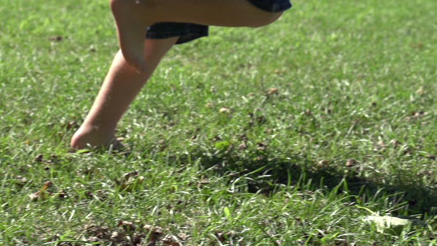 Boy running by in grass slow motion
