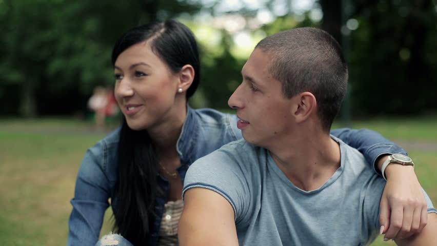 Happy teenage couple in love in the park, steadicam shot

