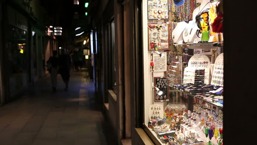 VENICE, ITALY - SEPTEMBER 2: A young couple enters a souvenir shop during evening promenade in the center of Venice on September 2, 2012