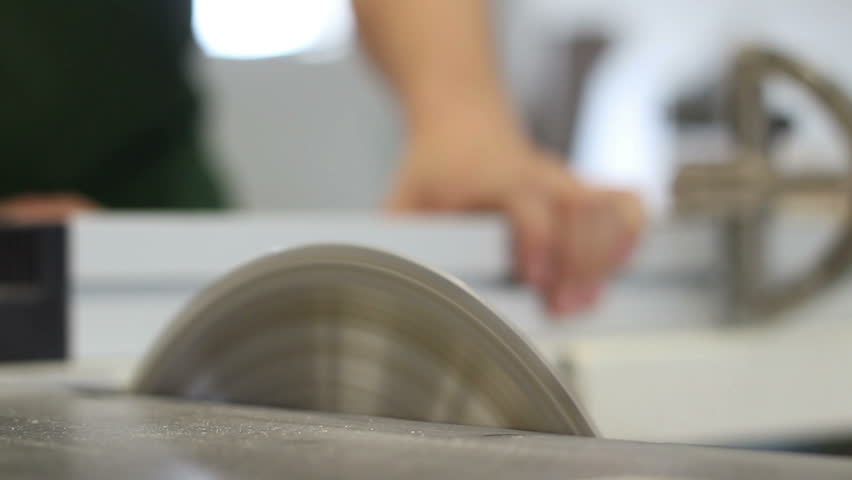 Carpenter working with circular blade saw, splitting  brown wooden desk (selective focus)