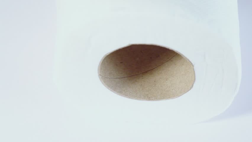 Simple roll of toilet paper spins on white background
