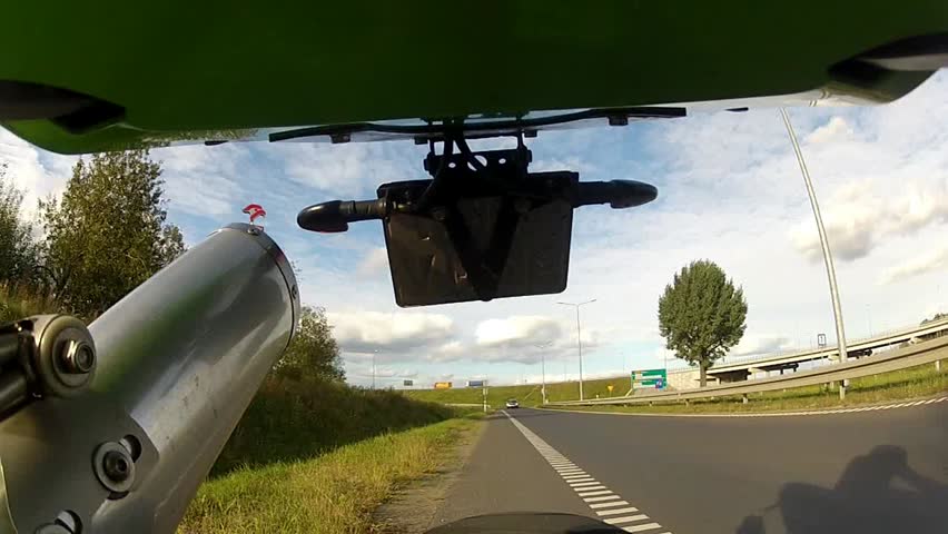 Motorcycle starts fast ride - view facing backwards 