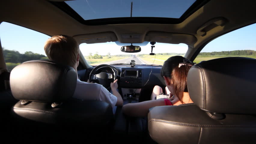 guy drive car on highway through fields, and nearby girl draws Japanese crossword puzzle