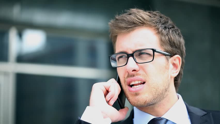 Handsome businessman at phone in the city