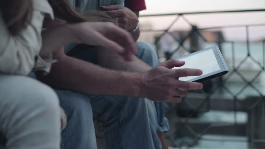 Three friends with tablet computer, outdoor, steadicam shot

