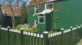 Zaanse Schans, Holland, traditional painted wooden house pan left to lane flowering shrub
