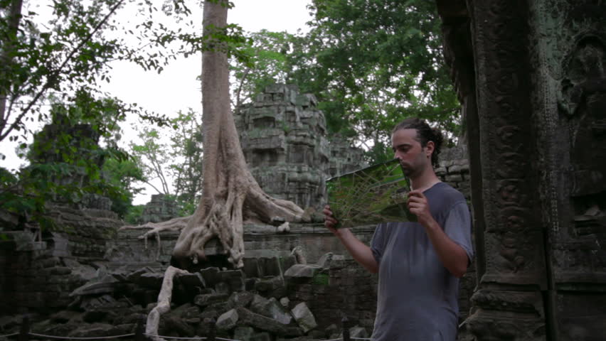 Visitor get bored with guide in Ta Prohm temple, Angkor