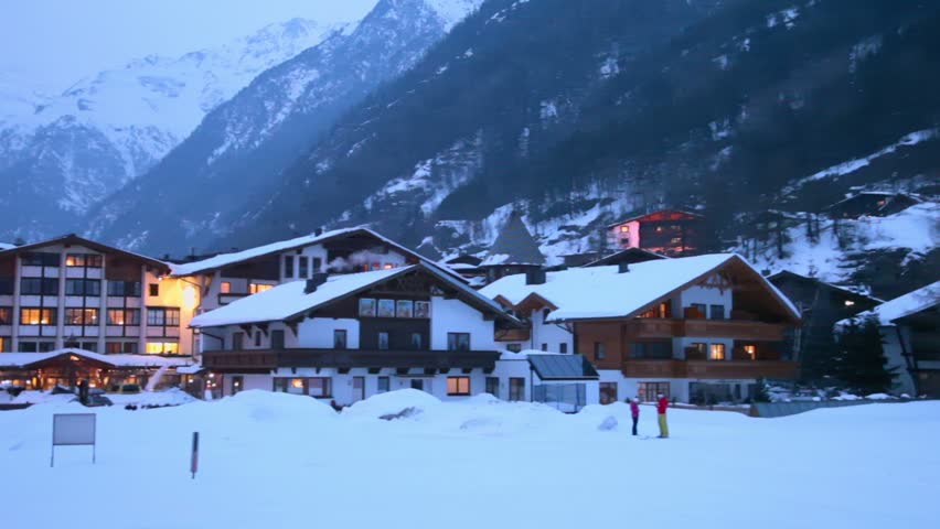 Village in mountains at winter evening, panoramic motion
