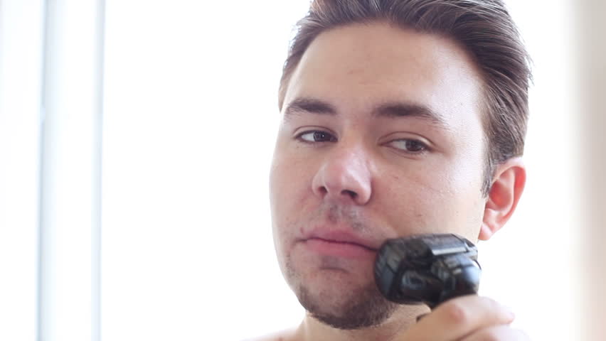 Young man shaving.
