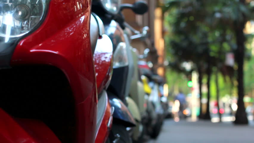 dynamic motorcycles, scooters, and mopeds parked on city street