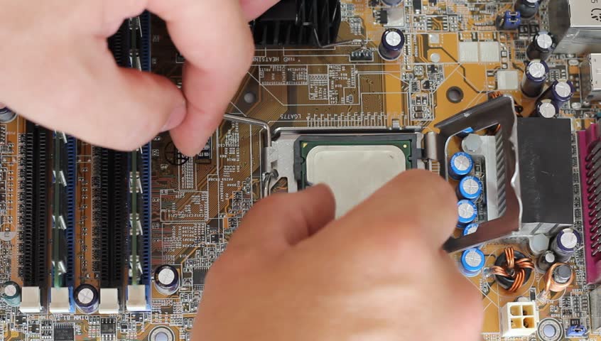Man pulls out a computer processor from the motherboard. 